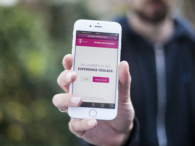 Version 5.0 der XTB: im responsiven Webdesign. Bild einer Hand, die ein Mobiltelefon mit der Loginmaske der Experience toolbox hält.
